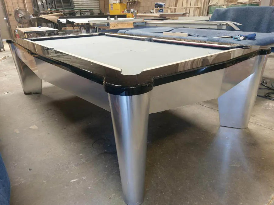 A custom pool table with brushed metal legs being finished in the workshop