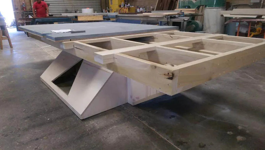 A custom pool table with a white angular cantilever base being built