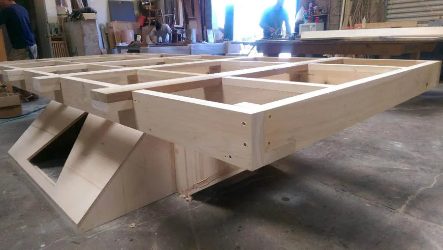 The white angular base of a custom pool table under construction