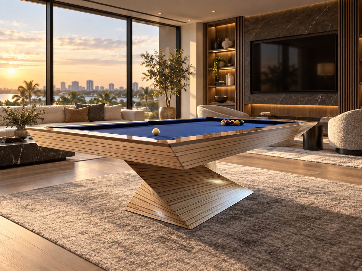 Light-wood pedestal pool table with blue cloth in a modern living room at sunset