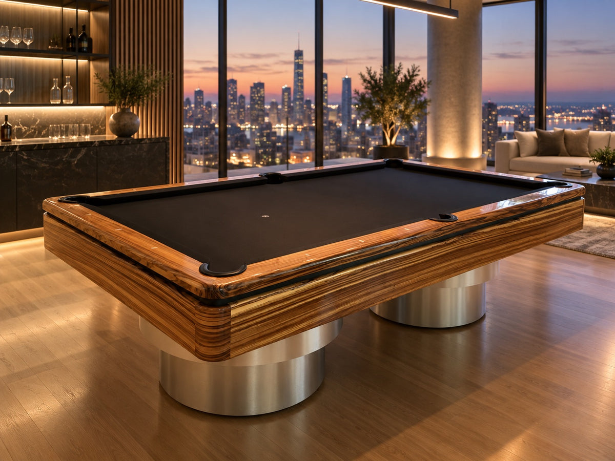 Zebrawood pool table with black cloth on twin chrome pedestals overlooking a city skyline at dusk