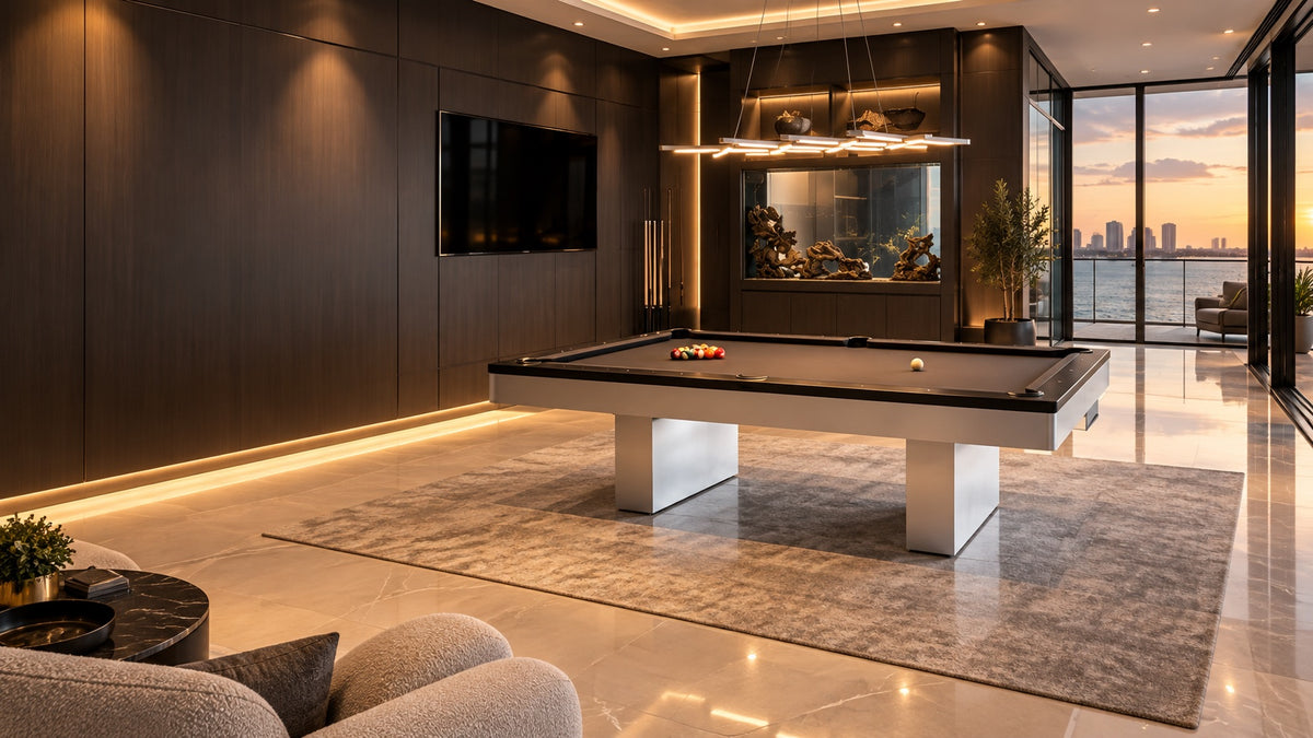 A modern pool table with grey cloth and dark rails on a grey rug, in a dark wood-panelled game room with city skyline views